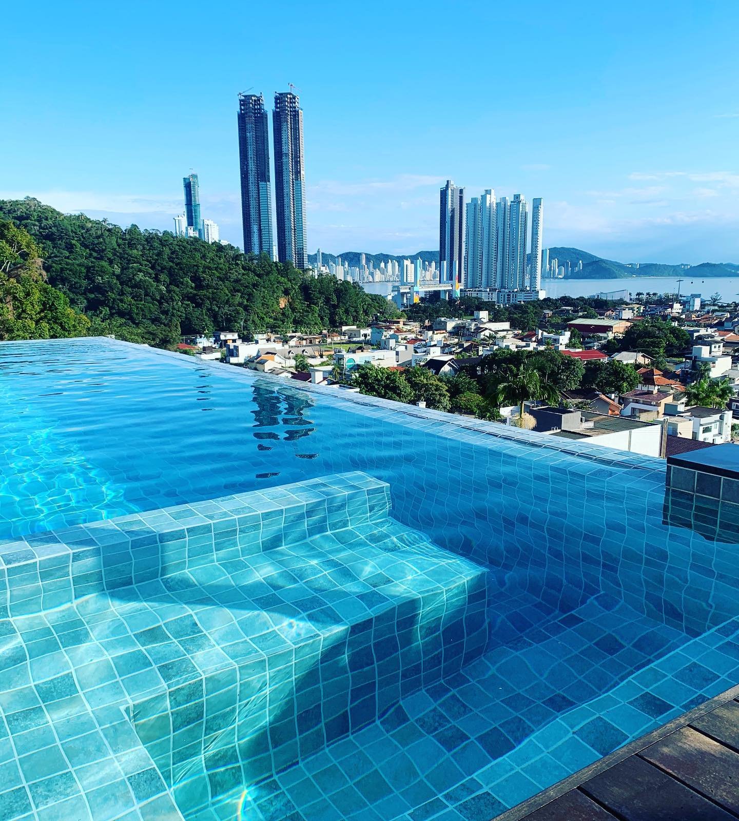 Piscina com água cristalina em cobertura, com vista para a cidade e o mar (foto Giba Pool)